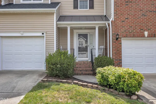 a front view of a house with a garden and plants