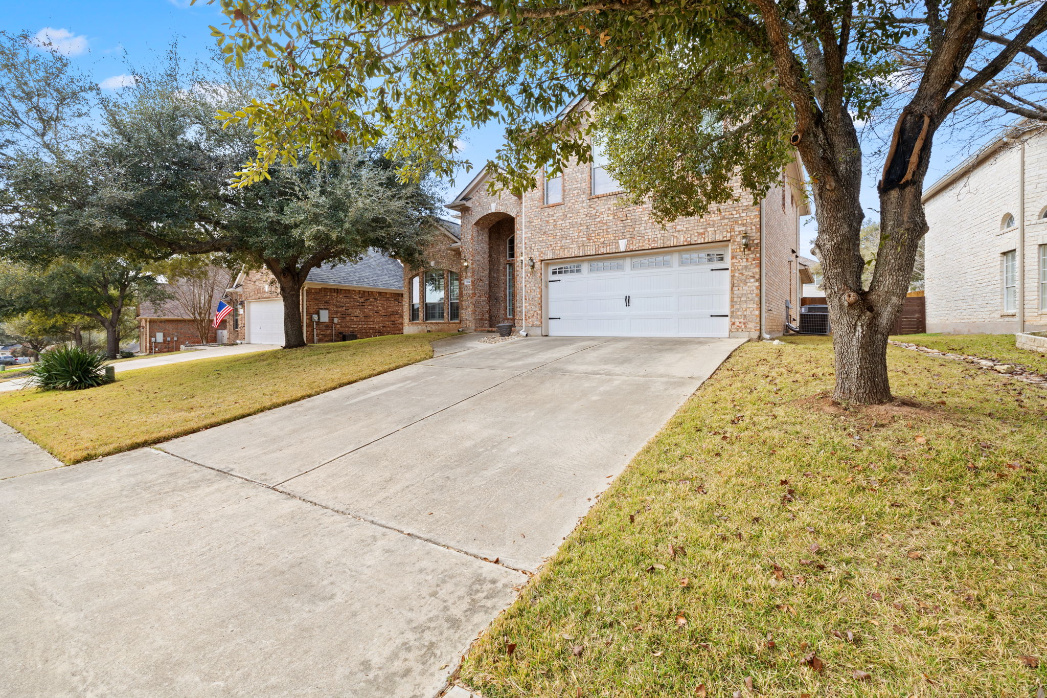 8112 Cobblestone Austin, TX 78735 - Photo 2 of 33 Traditional home featuring driveway, a garage, brick siding, and a front yard