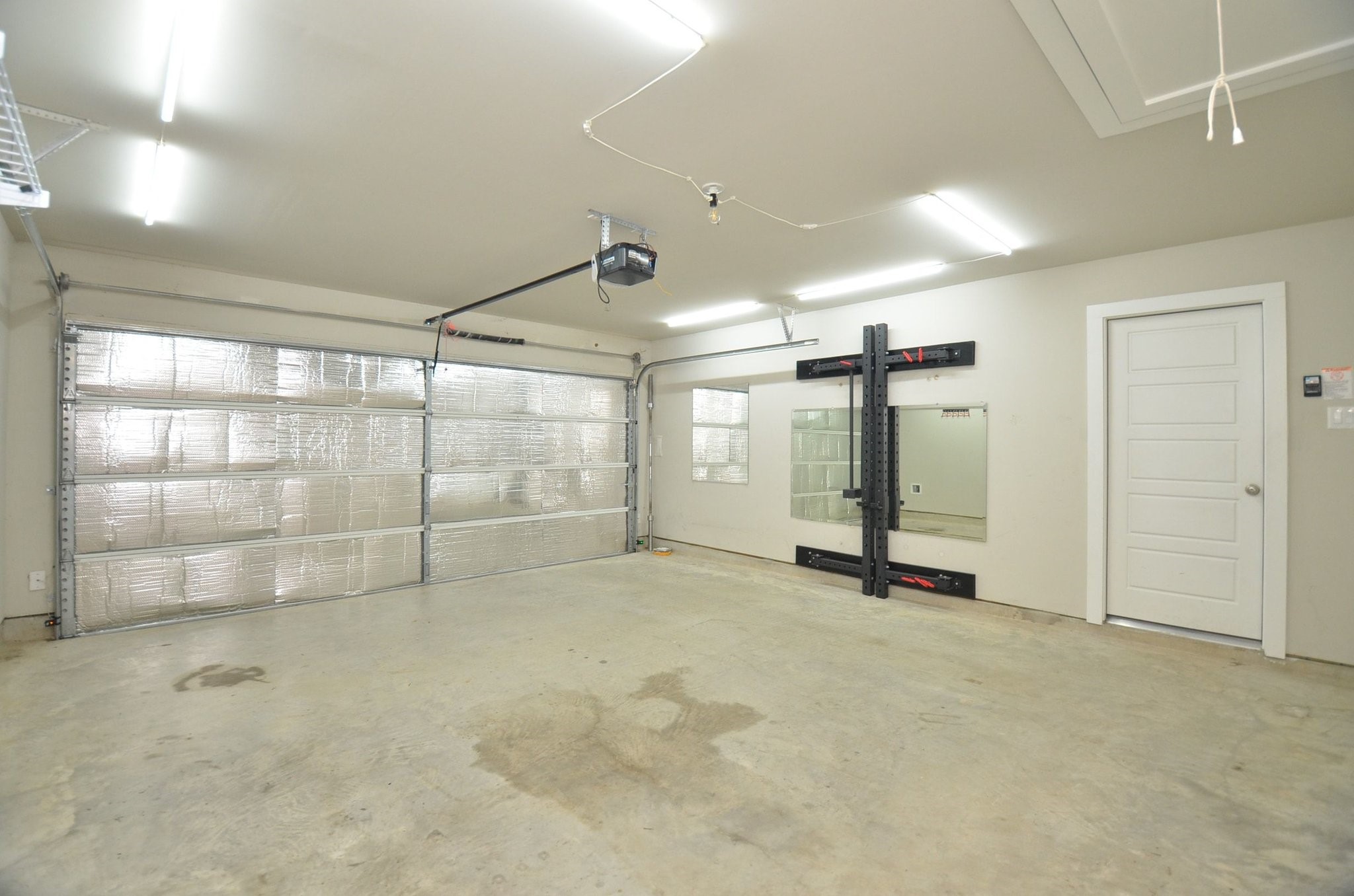 8230 Blue Fish Drive Cypress, TX 77433 - Photo 18 of 18 Fully finished garage with insulated garage door, additional lighting, as well as a fold up power rack for use.