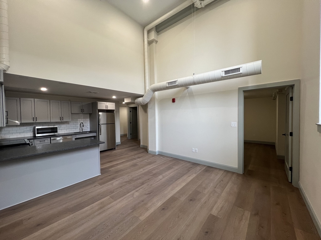 160 Seabury Street, Unit 18 Fall River, MA 02720 - Photo 3 of 11 a view of a kitchen with a sink and wooden floor