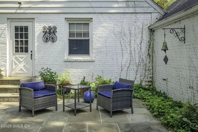 a backyard of a house with table and chairs