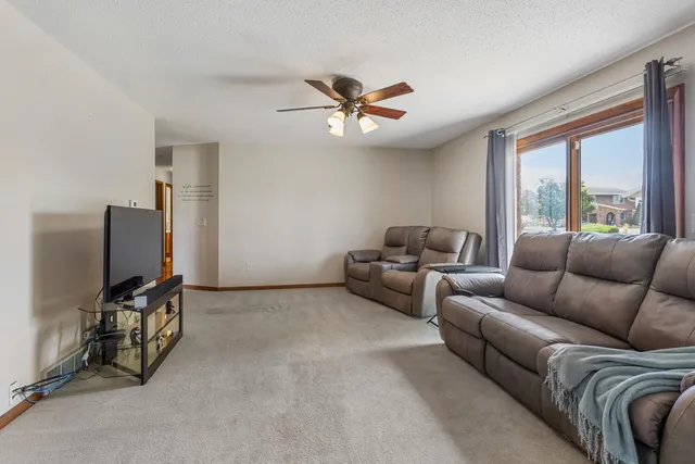 a living room with furniture a ceiling fan and a window