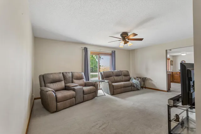 a living room with furniture and a ceiling fan
