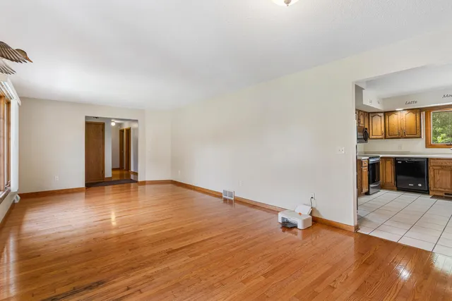 an empty room with wooden floor and fireplace