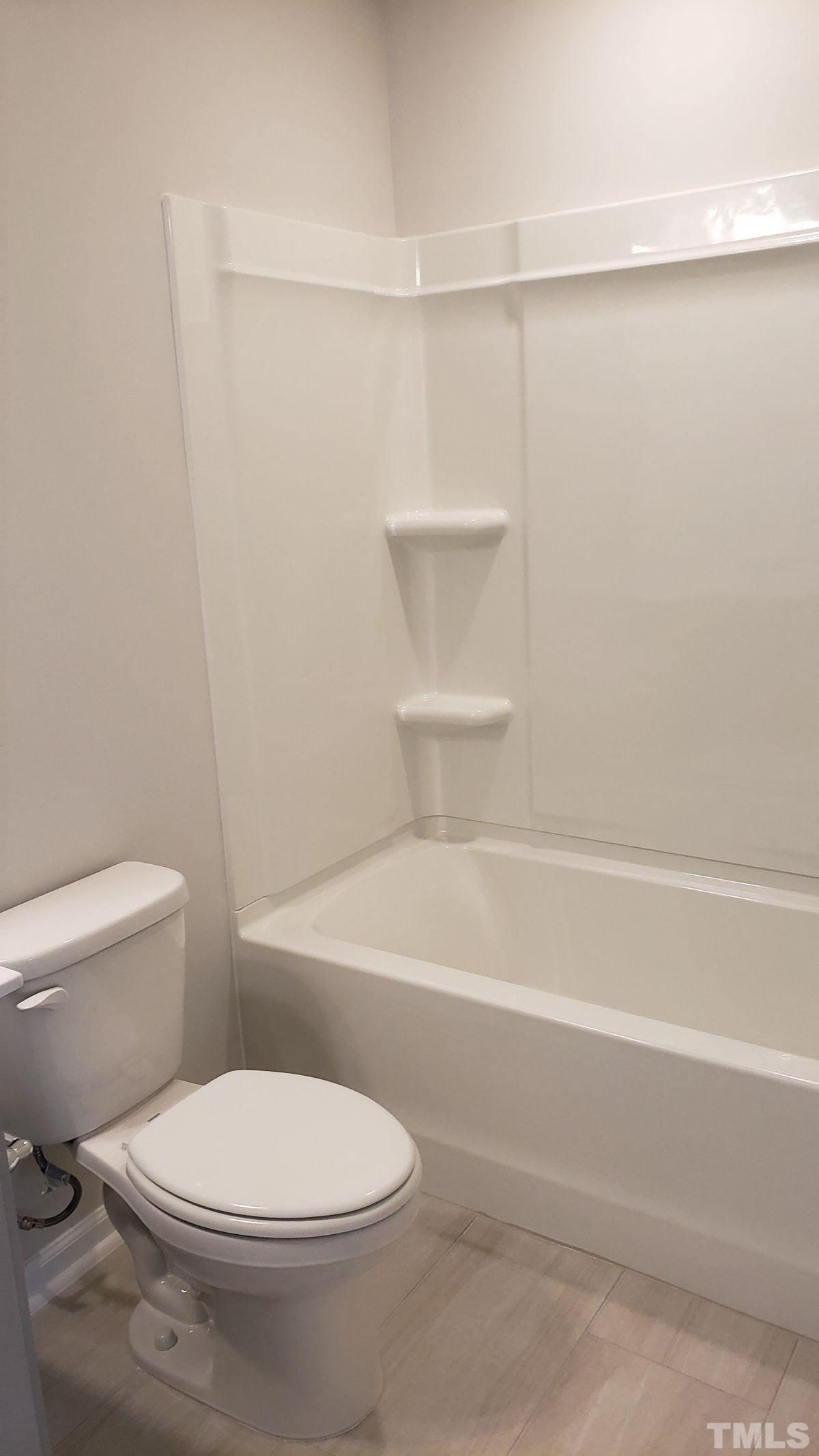 1833 Joscara Lane, Unit 1833 Apex, NC 27502 - Photo 28 of 37 a white toilet sitting next to a bath tub