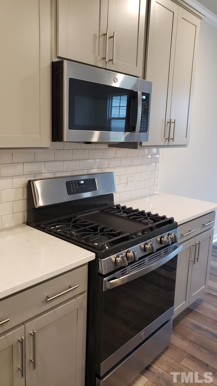 1833 Joscara Lane, Unit 1833 Apex, NC 27502 - Photo 8 of 37 a kitchen with stainless steel appliances a stove microwave and sink
