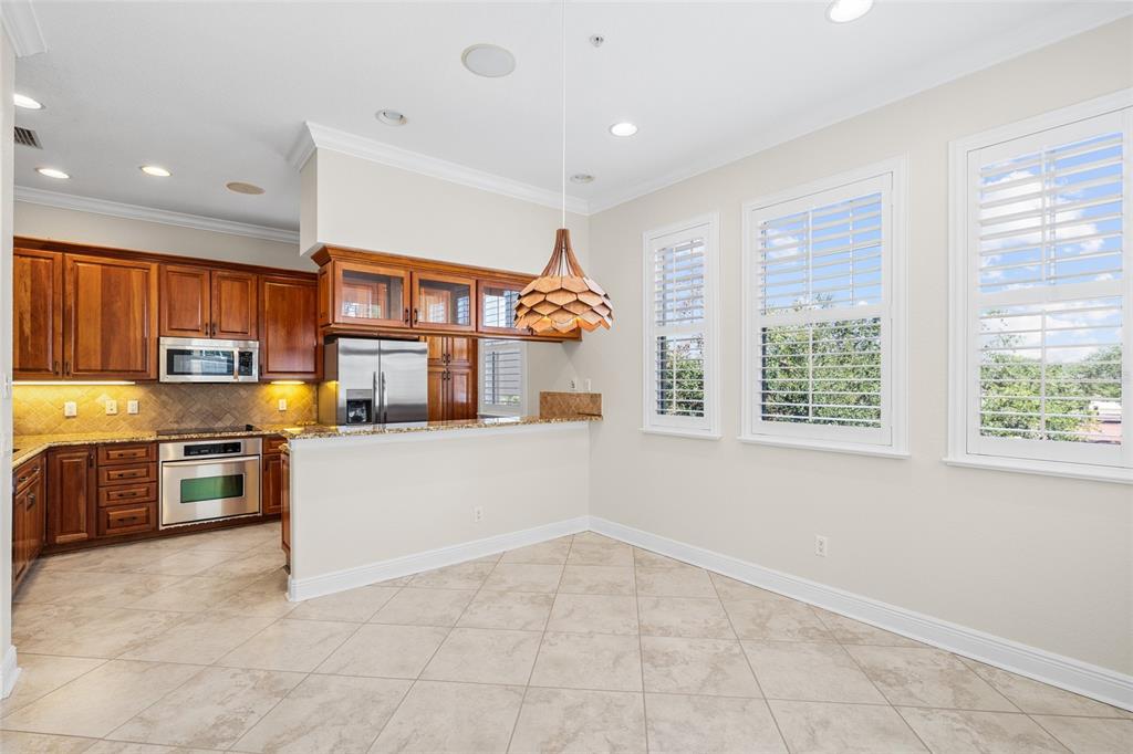 6002 Printery Street, Unit 105 Tampa, FL 33616 - Photo 14 of 64 a kitchen with stainless steel appliances granite countertop a stove and a refrigerator
