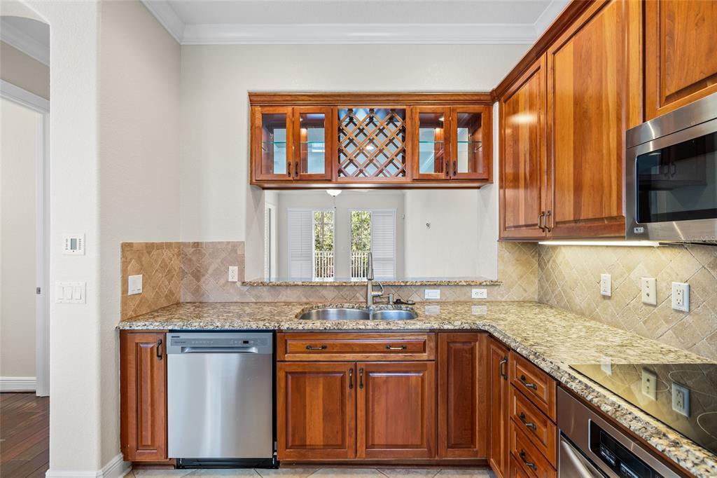 6002 Printery Street, Unit 105 Tampa, FL 33616 - Photo 16 of 64 a kitchen with stainless steel appliances granite countertop a sink stove and cabinets