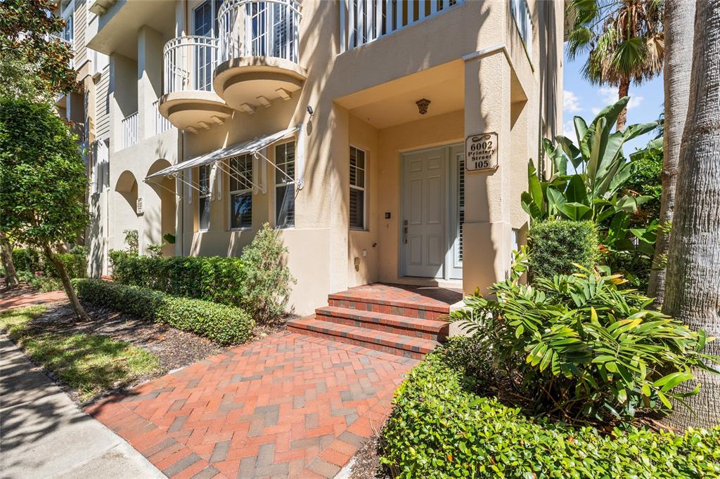 6002 Printery Street, Unit 105 Tampa, FL 33616 - Photo 2 of 64 a front view of a house with a yard and flowers