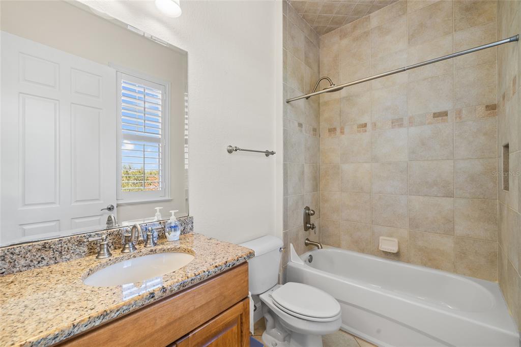 6002 Printery Street, Unit 105 Tampa, FL 33616 - Photo 23 of 64 a bathroom with a granite countertop bathtub shower sink vanity mirror and toilet