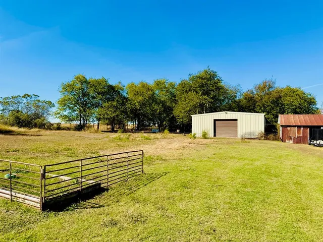 a view of a swimming pool with a bench and lawn chair under an umbrella