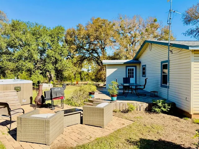 a view of house with patio outdoor seating and covered with trees
