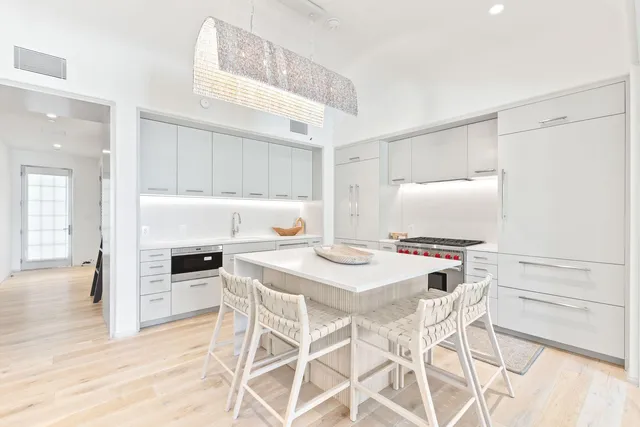a kitchen with stainless steel appliances a stove a table and chairs