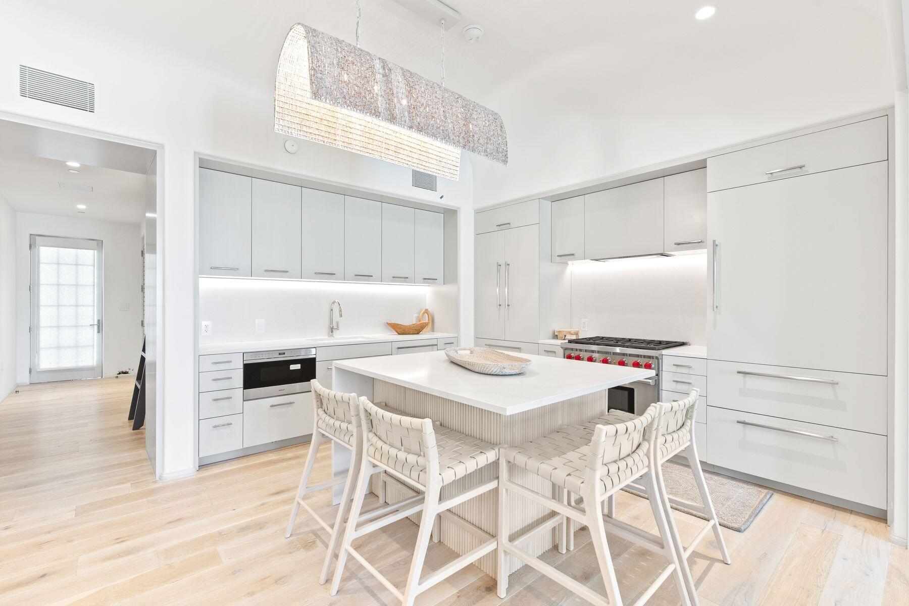 45 West Solaire Way Inlet Beach, Unit 103 Inlet Beach, FL 32461 - Photo 8 of 25 a kitchen with stainless steel appliances a stove a table and chairs