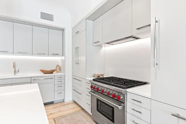 a kitchen with stainless steel appliances a stove a microwave and cabinets