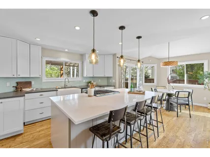 a kitchen with a dining table chairs and white cabinets