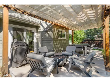 a view of a patio with table and chairs with wooden floor and fence