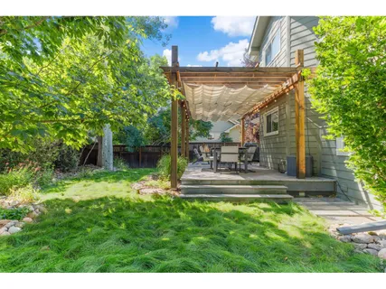 a view of a patio with table and chairs potted plants with wooden floor and fence