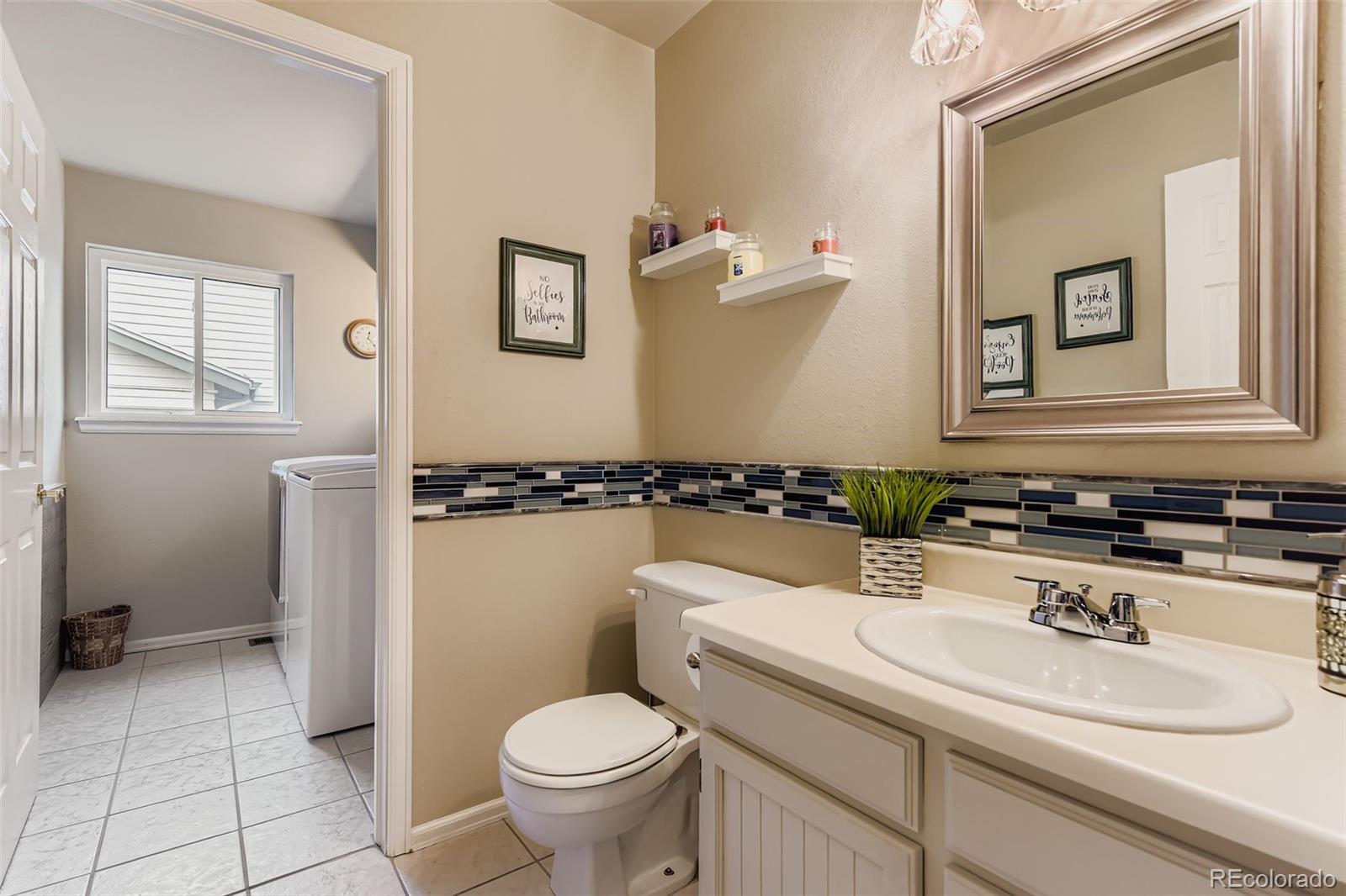1055 Northridge Road Highlands Ranch, CO 80126 - Photo 14 of 32 a bathroom with a sink toilet and mirror