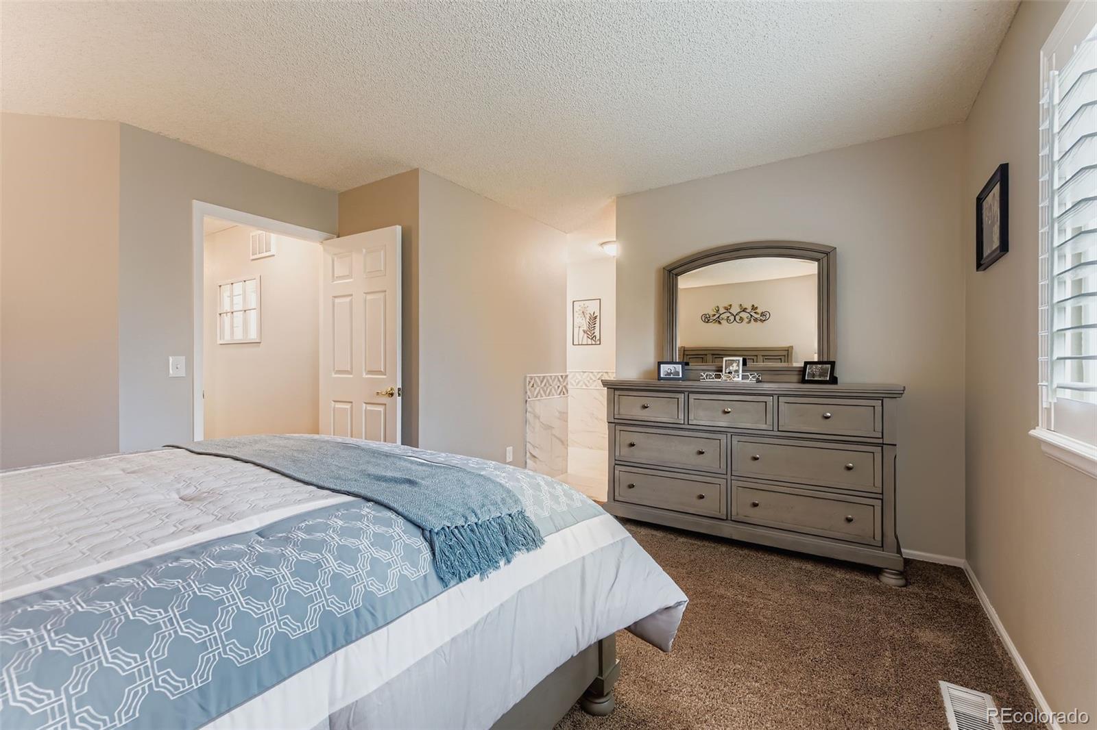 1055 Northridge Road Highlands Ranch, CO 80126 - Photo 17 of 32 a bedroom with a bed and a dresser