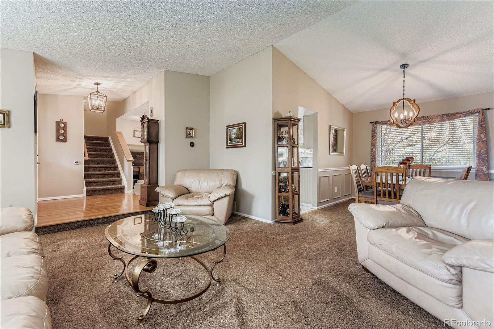 1055 Northridge Road Highlands Ranch, CO 80126 - Photo 5 of 32 a living room with furniture a dining table and a chandelier