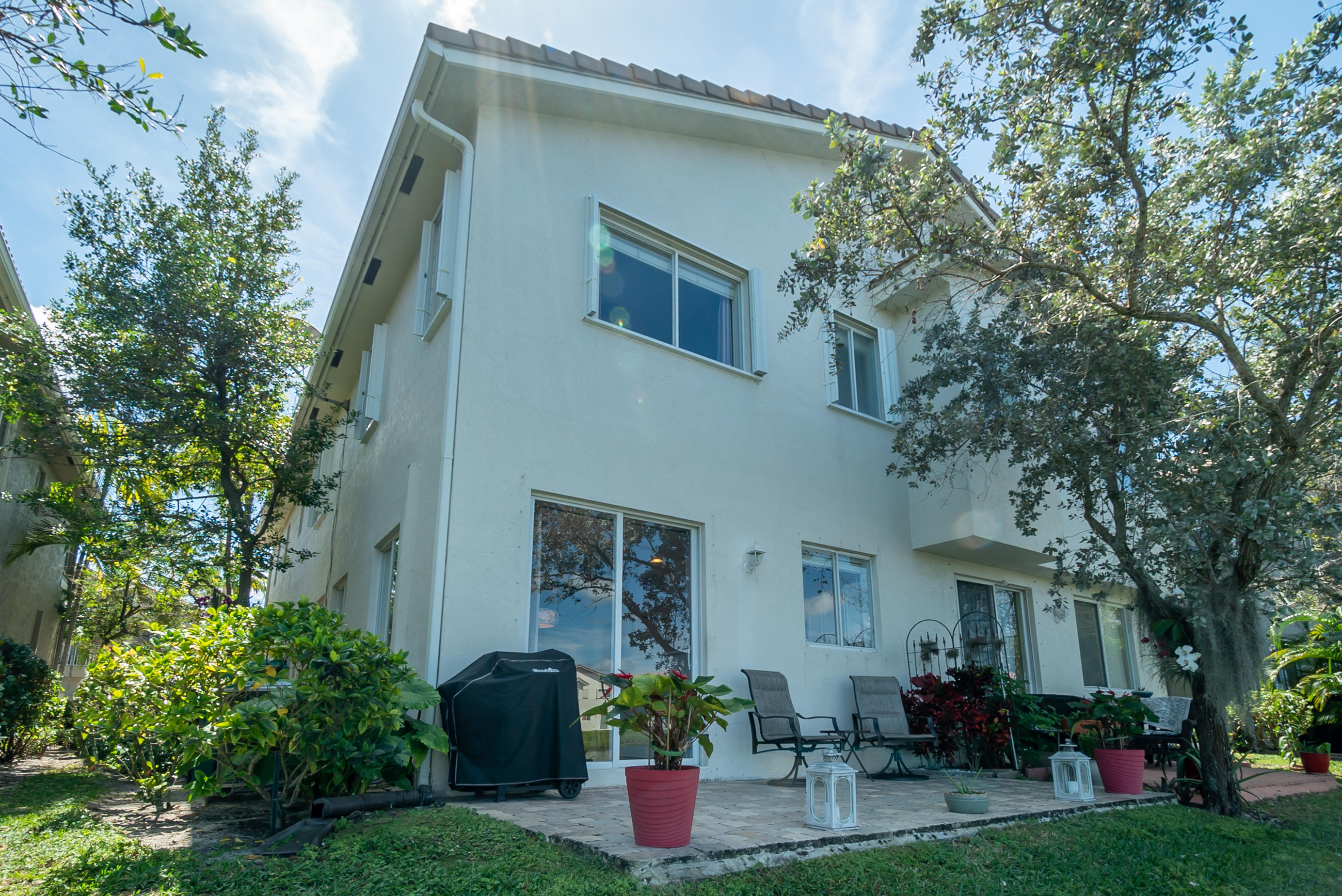 3170 Laurel Ridge Circle Riviera Beach, FL 33404 - Photo 26 of 27 a backyard of a house with wooden table and sofas