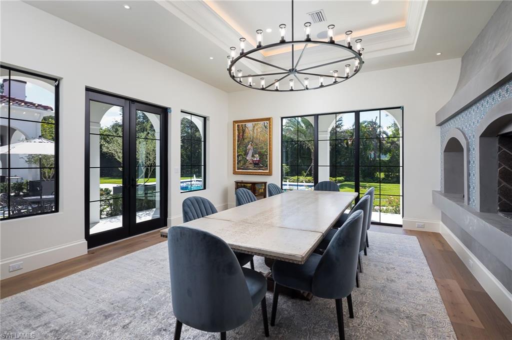 Undisclosed Address Naples, FL 34108 - Photo 10 of 16 a view of a dining room with furniture large windows and wooden floor