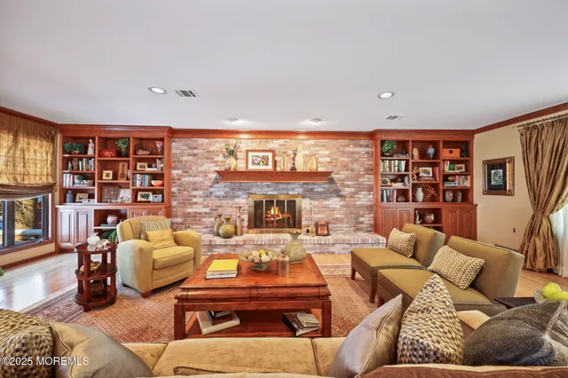 a living room with furniture large windows and wooden floor