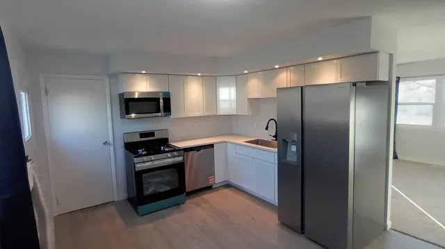 a kitchen with a refrigerator and a stove top oven