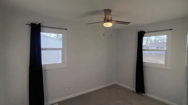 an empty room with windows and closet