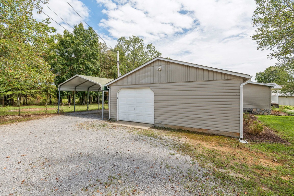 11201 New Zion Road Christiana, TN 37037 - Photo 13 of 19 a backyard of a house with plants and brick wall