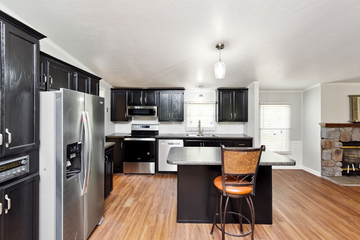 11201 New Zion Road Christiana, TN 37037 - Photo 2 of 19 a kitchen with stainless steel appliances a refrigerator stove a sink a dining table and chairs with wooden floor