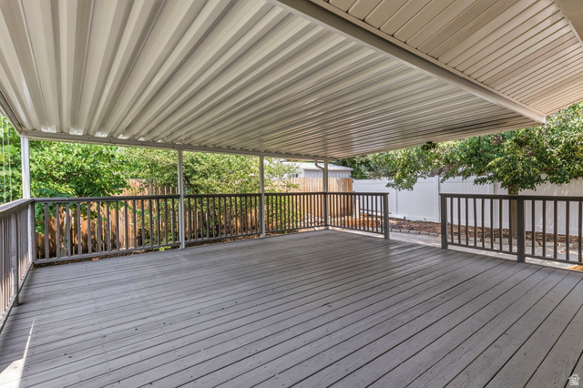 2693 Teal Way Sandy, UT 84093 - Photo 40 of 50 Expansive covered deck featuring gray wood-finish flooring, a white corrugated metal overhead, and dark wood railings