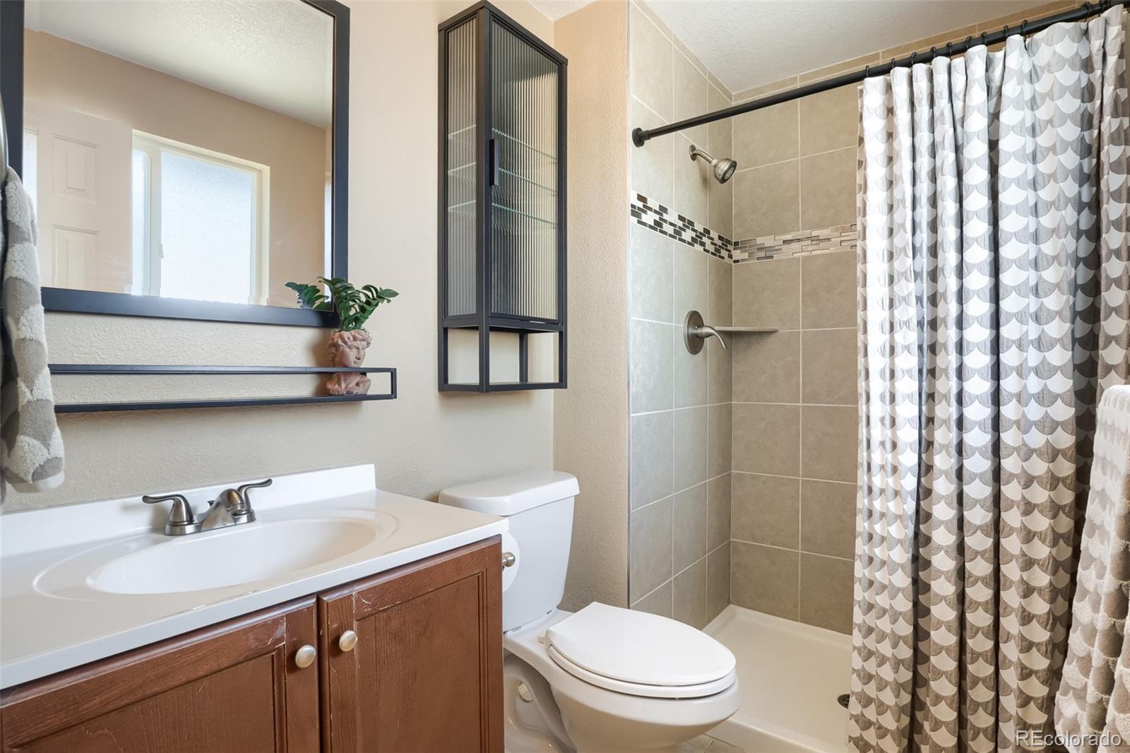 6551 South Albion Way Littleton, CO 80121 - Photo 12 of 37 a bathroom with a sink toilet and shower