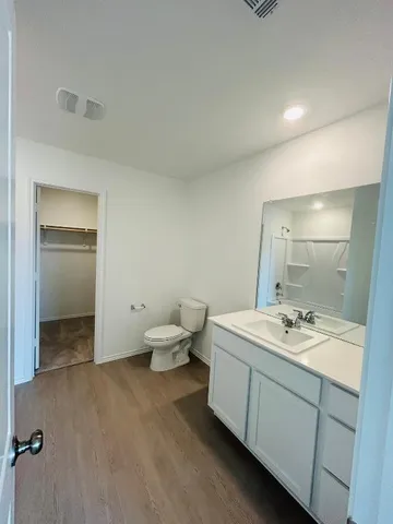 a bathroom with a granite countertop sink a toilet and mirror