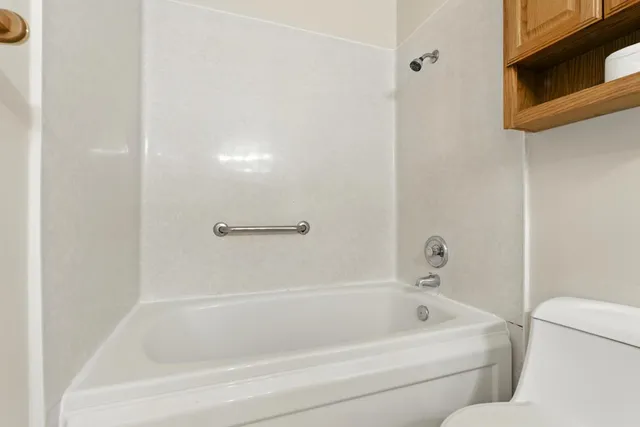 an empty room with a chandelier fan and windows