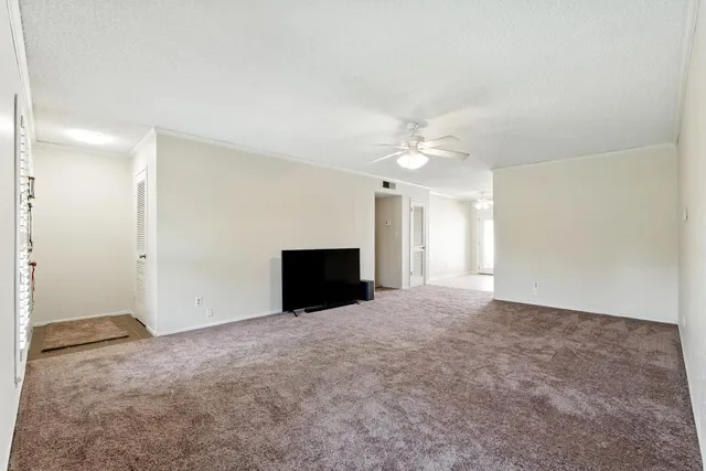 an empty room with windows and fireplace