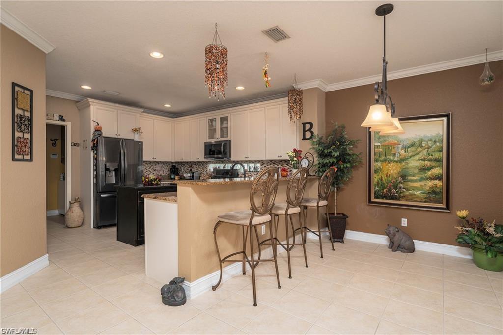 1562 Double Eagle Trail Naples, FL 34120 - Photo 3 of 13 a kitchen with refrigerator and microwave