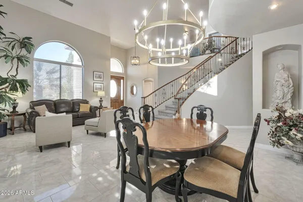 a dining room with wooden floor a chandelier a wooden table and chairs