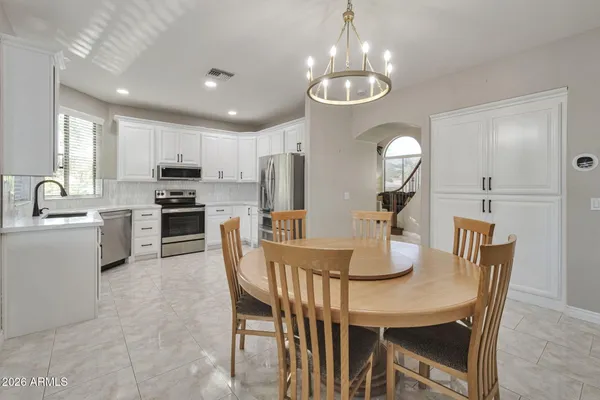 a kitchen with microwave a refrigerator and chairs