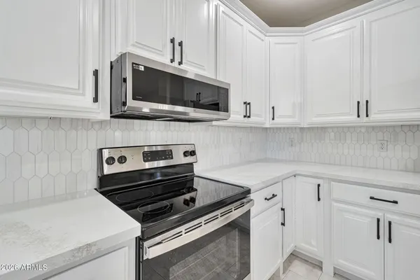 a kitchen with white cabinets and stainless steel appliances