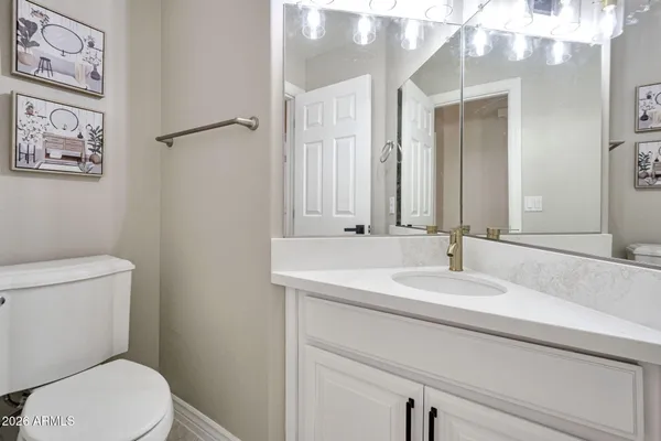 a bathroom with a granite countertop toilet sink and mirror