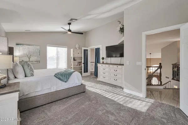 a spacious bedroom with a large bed and a chandelier