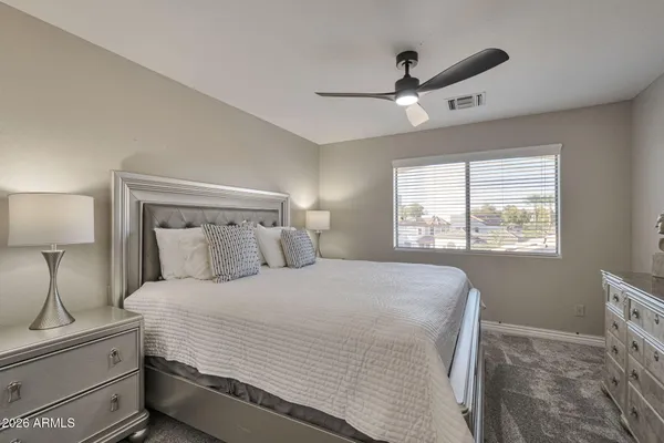 a bedroom with a large bed and a chandelier