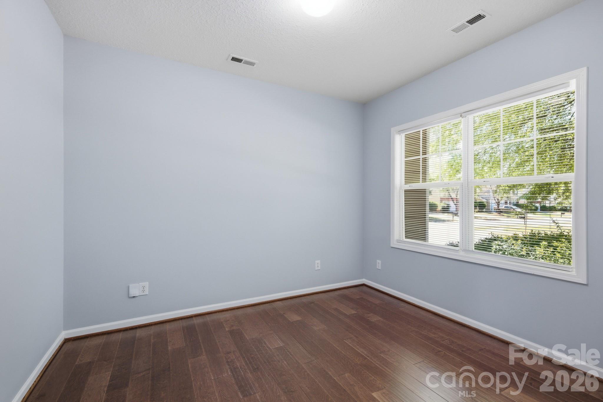 6404 Trotters Ridge Road Charlotte, NC 28227 - Photo 15 of 29 a view of an empty room with wooden floor and a window