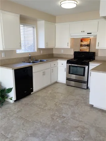 a kitchen with granite countertop a stove and a sink