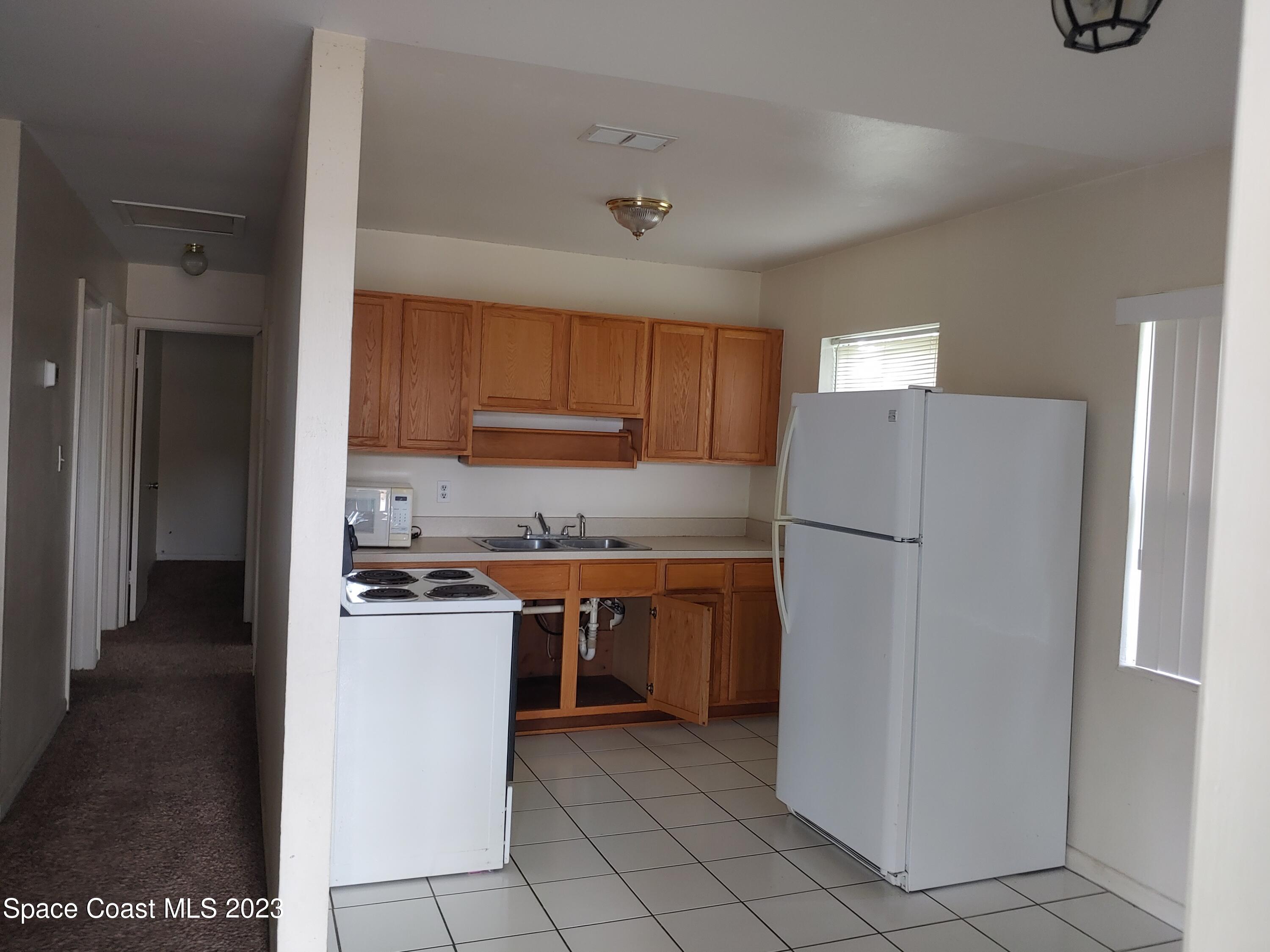 2579 Pepper Avenue Melbourne, FL 32935 - Photo 2 of 5 a kitchen with stainless steel appliances granite countertop a refrigerator and a sink