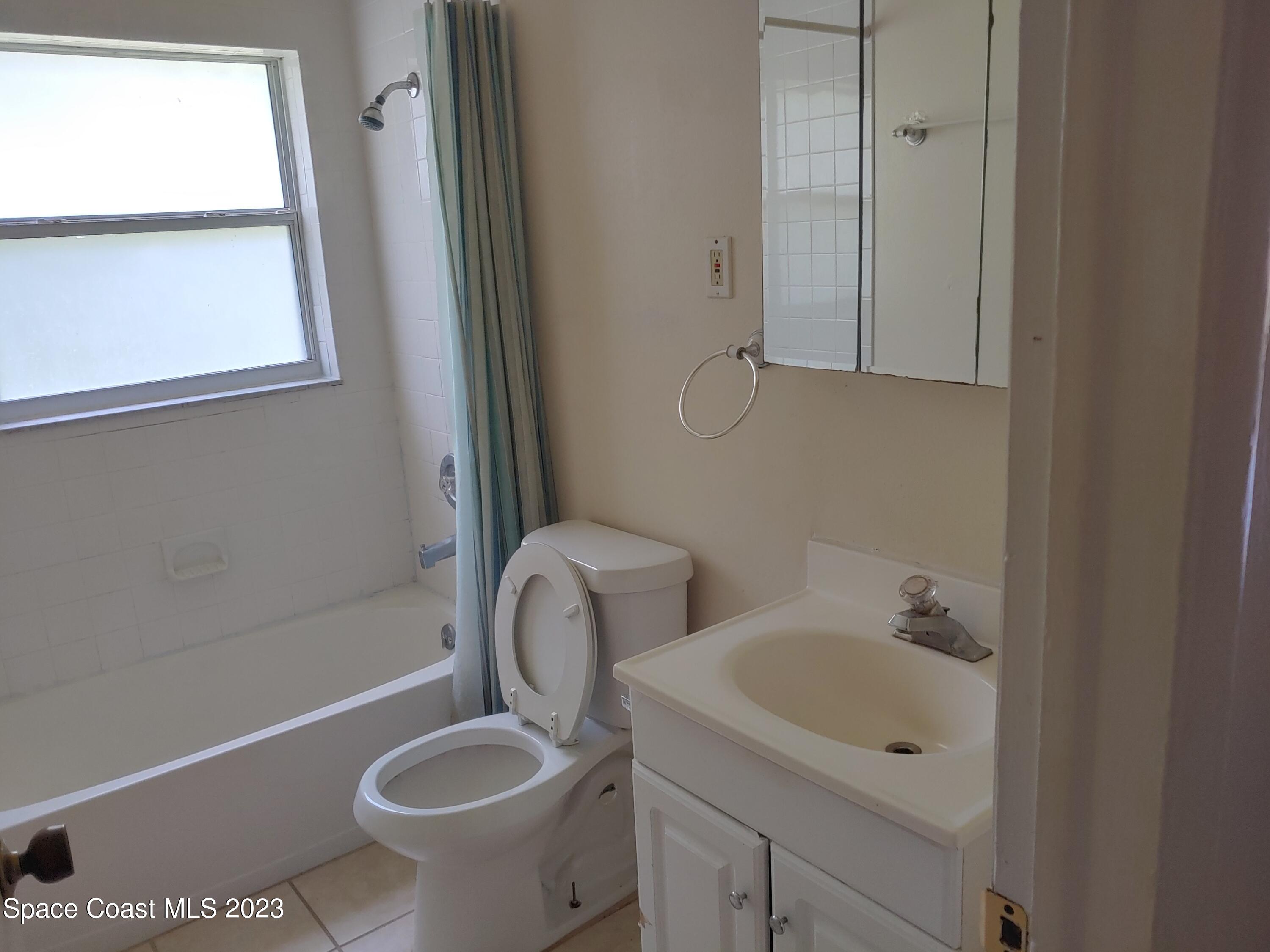 2579 Pepper Avenue Melbourne, FL 32935 - Photo 5 of 5 a bathroom with a toilet sink and mirror