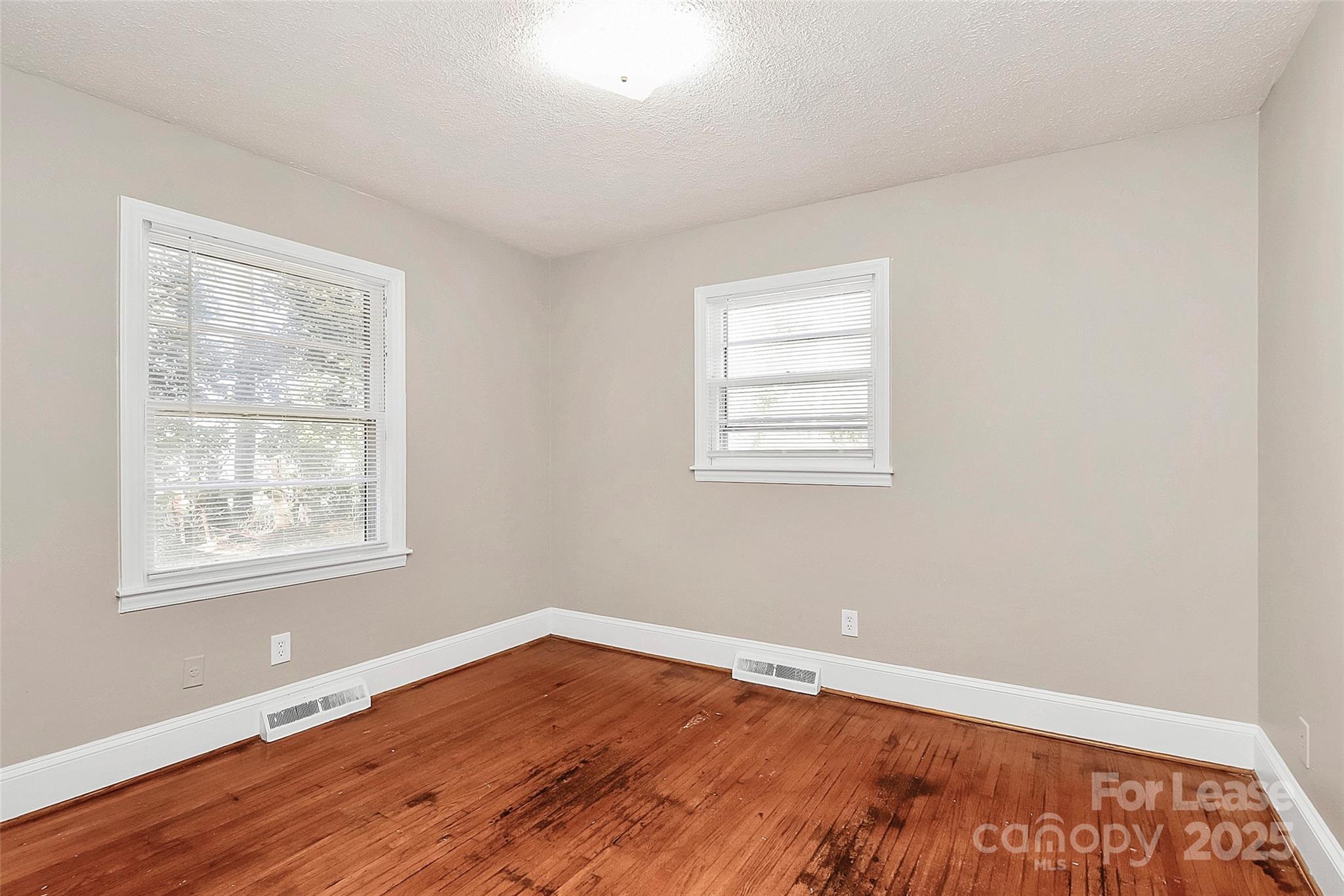 4919 Raymond Place Charlotte, NC 28205 - Photo 11 of 31 an empty room with wooden floor and windows