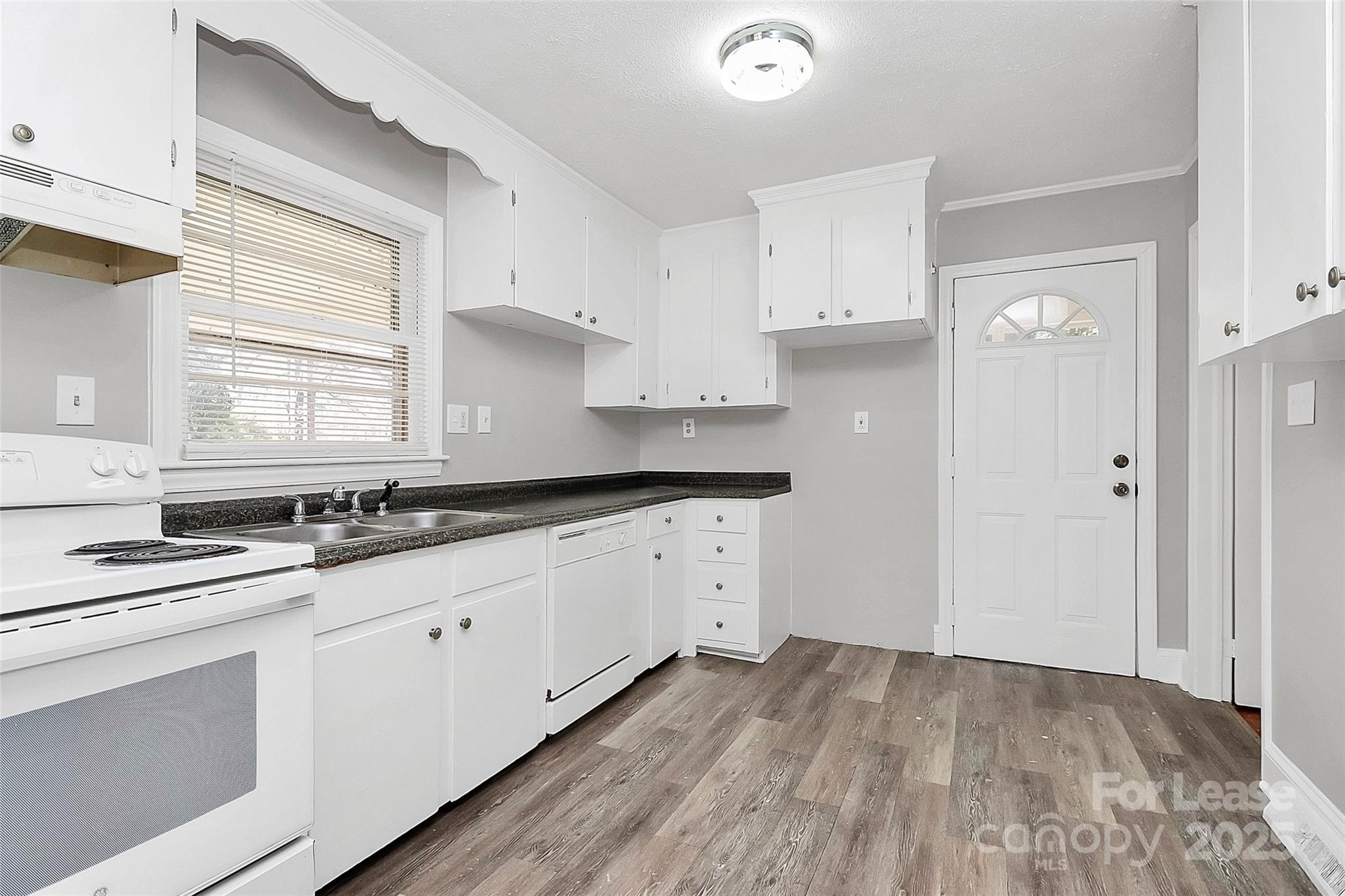 4919 Raymond Place Charlotte, NC 28205 - Photo 20 of 31 a kitchen with granite countertop white cabinets and white appliances